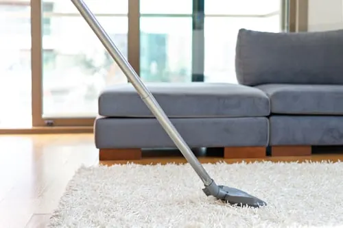 A living room being vacuumed during a YM Elite Cleaners visit